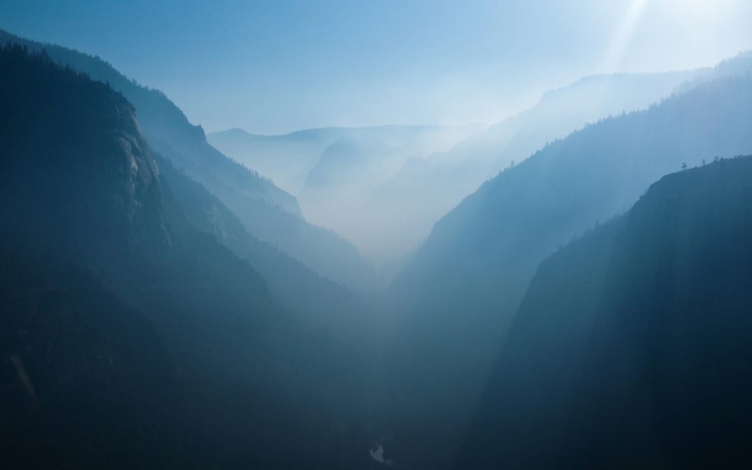 a misty valley between mountains with soft light
