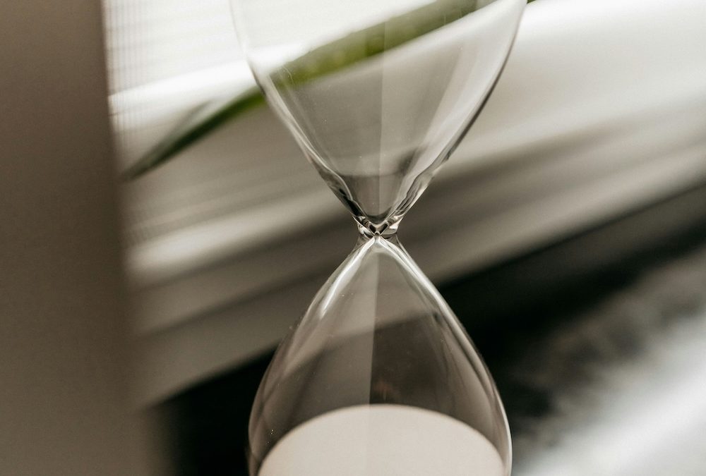 : A glass hourglass with all the sand settled at the bottom, the top chamber empty.